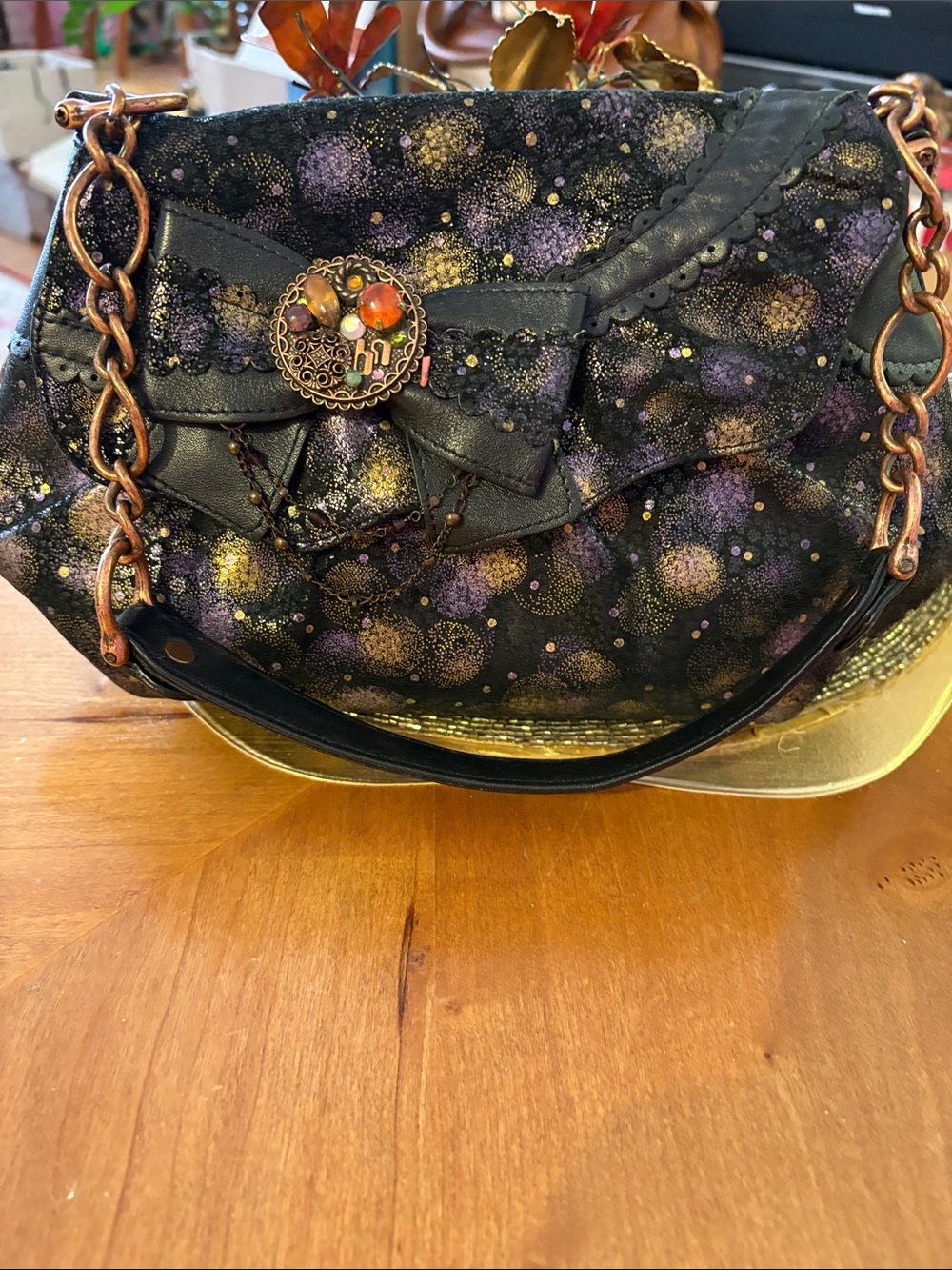 Decorative Black Shoulder Bag with Purple and Gold Accents. Leather